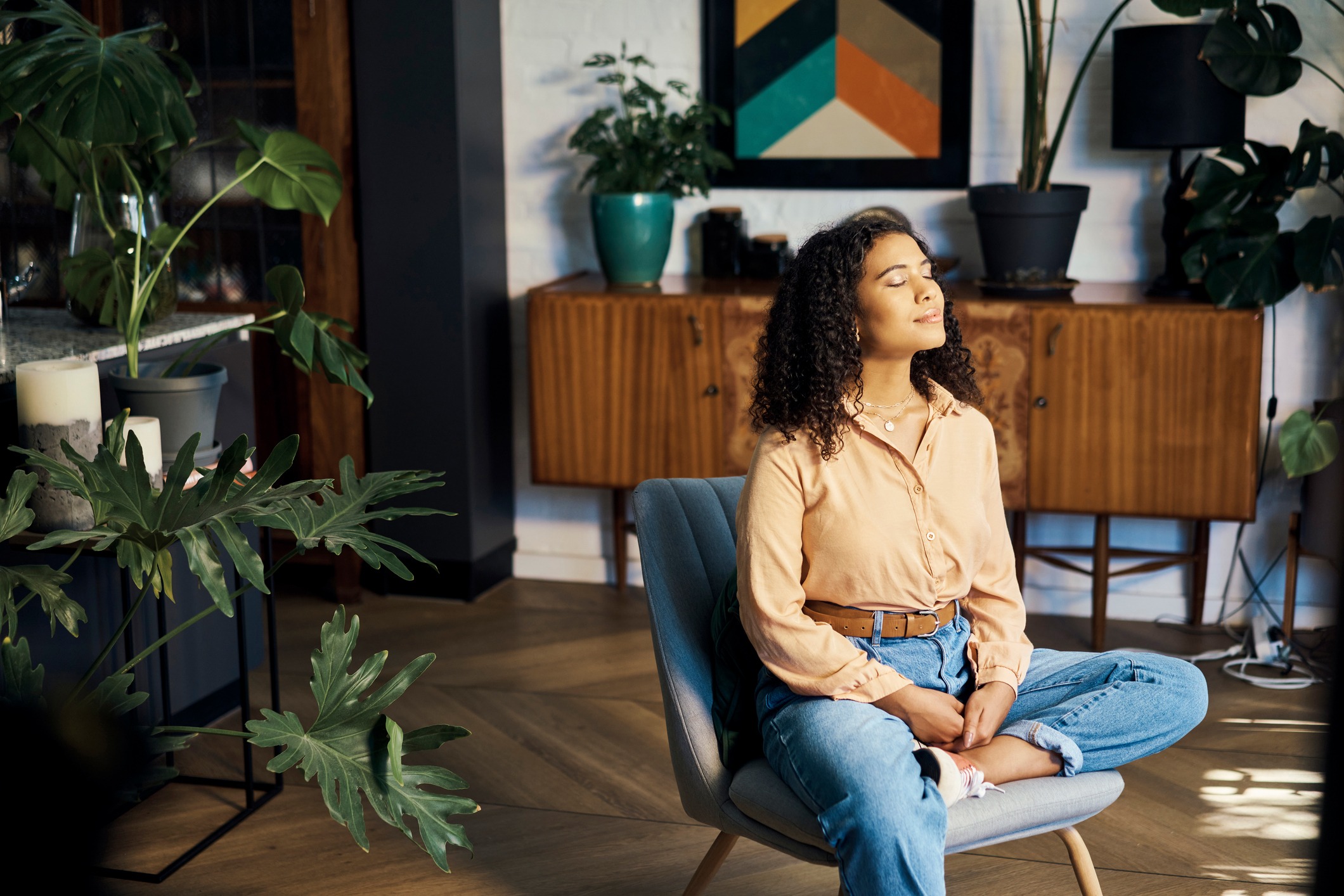 Peace, relax and happy mindset of a woman from Indonesia taking a mind and meditation home break. Happiness of woman on a house living room lounge chair thinking about life, gratitude and self care